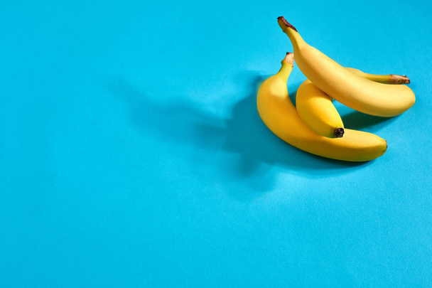 frische Bananen aus nächster Nähe auf hellblauem Hintergrund. flach lag. Sommerkonzept. - Foto, Bild
