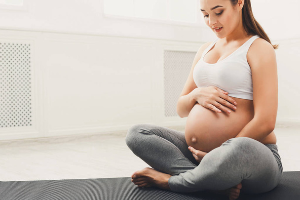 Mulher grávida acariciando sua barriga em casa - Foto, Imagem