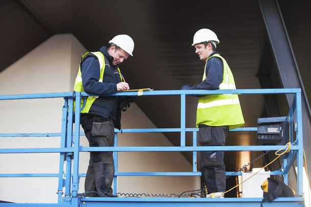 Foreman en bouw werknemer op constraction site - Foto, afbeelding