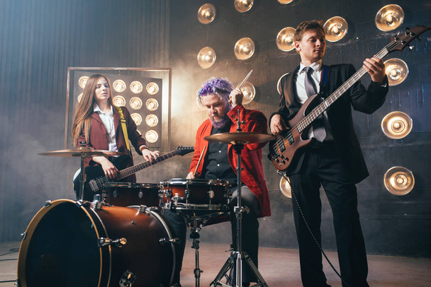 музыканты в костюмах на сцене со светом, в стиле ретро, гитаристы и барабанщики, рок-группа
 - Фото, изображение