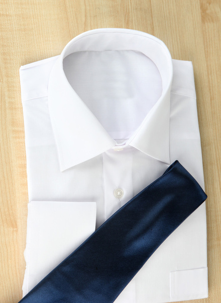 New white man's shirt with color tie on wooden background - Photo, image