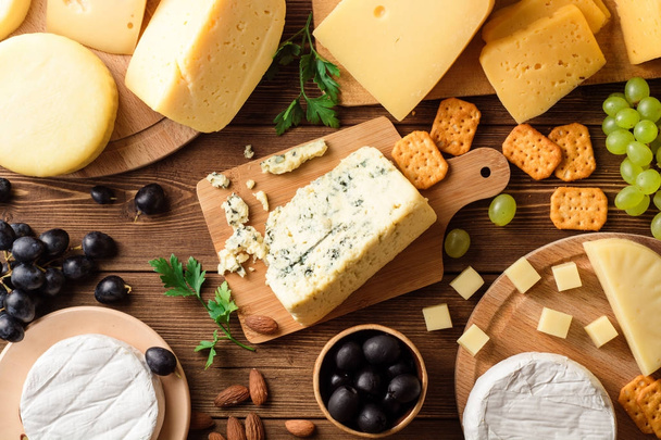 Various types of cheese on dark rustic wooden background. - 写真・画像