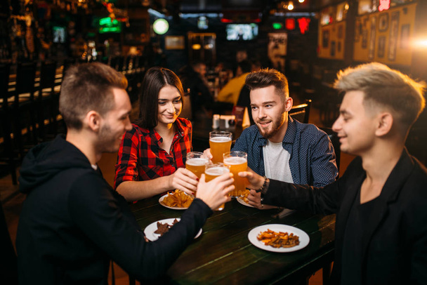 companhia feliz de amigos levantou seus copos com cerveja no bar esporte, lazer de fãs de futebol
 - Foto, Imagem