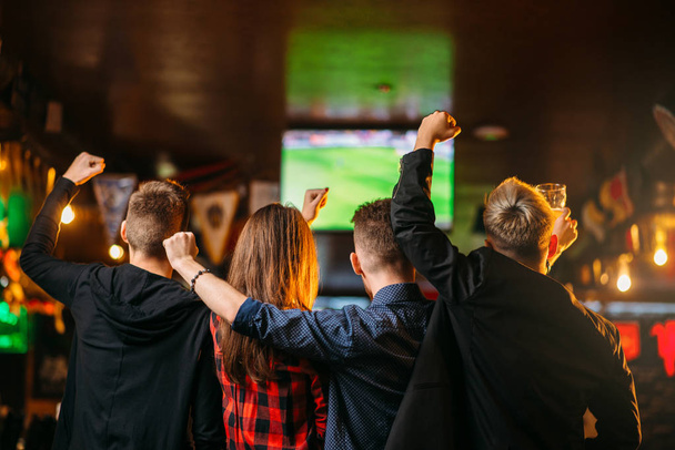 молоді схвильовані друзі, що святкують перемогу в іграх у спортивному барі, щаслива дружба футбольних фанатів
 - Фото, зображення
