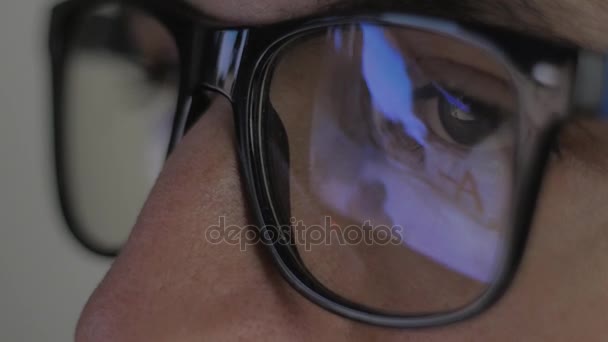 γκρο πλαν αντανάκλαση στα γυαλιά: Gamer παίζει ένα παιχνίδι βίντεο σε έναν υπολογιστή σε ένα σκοτεινό δωμάτιο - Πλάνα, βίντεο