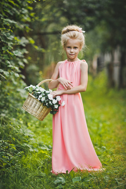 Child in pink dress walks in the garden 6586. - Foto, afbeelding
