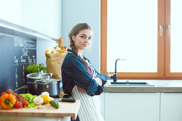 Young woman sitting on table in the kitchen. - Photo, Image