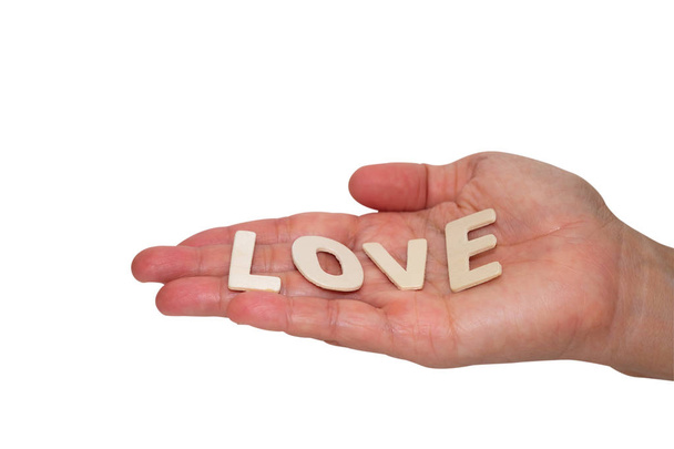 Wooden letters word "LOVE" on woman's hand, Valentine day concept isolated on white background. - Foto, Imagen