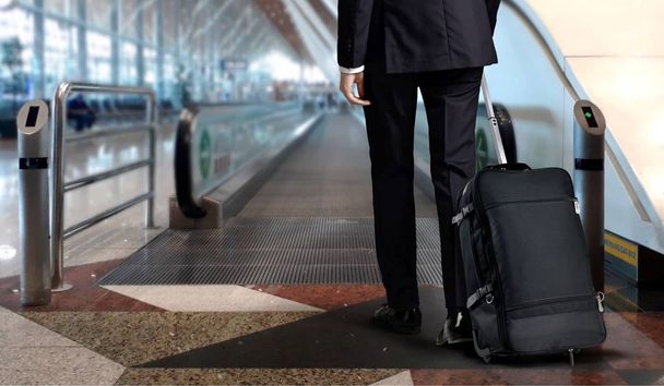 Homme en costume tirant sa valise au terminal de l'aéroport
 - Photo, image
