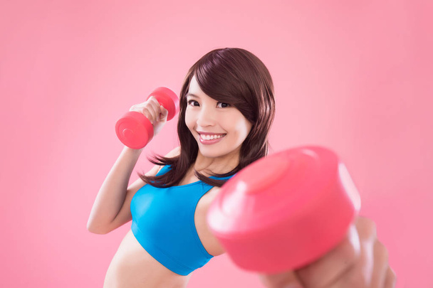 beauty sport woman with  dumbbells on the pink background - Фото, зображення