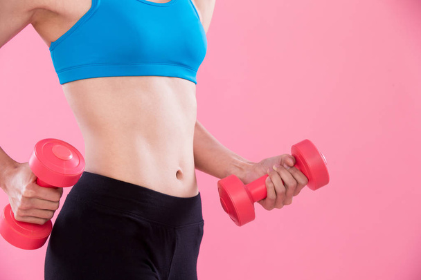 beauty sport woman with  dumbbell on the pink background - 写真・画像