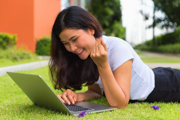 Молодая женщина с помощью компьютера ноутбук на скамейке в саду, открытый conce
 - Фото, изображение