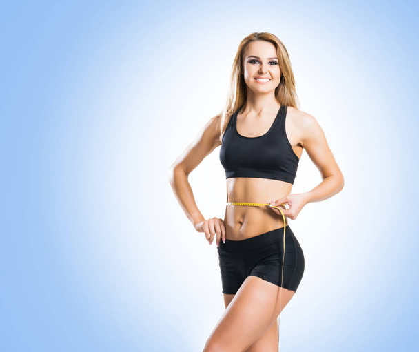 Fit body of beautiful, healthy and sporty woman. Slim woman posing in sportswear. - Фото, изображение