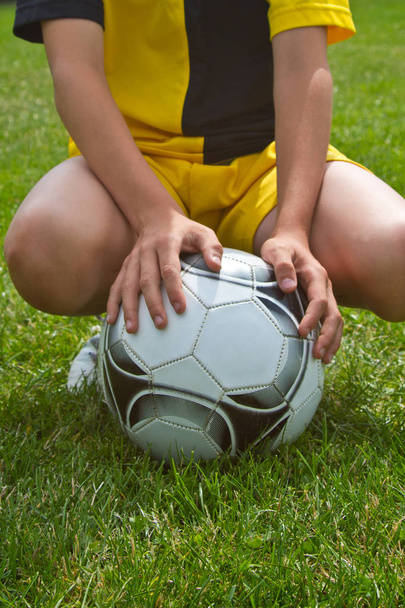 крупным планом игрок держит футбольный мяч на стадионе
 - Фото, изображение