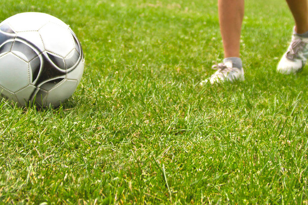 Ноги футболиста, пинающего мяч
 - Фото, изображение