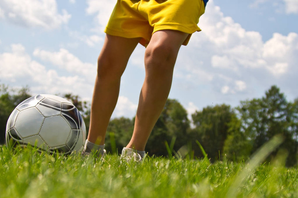 Ноги футболіста штовхають м'яч
 - Фото, зображення