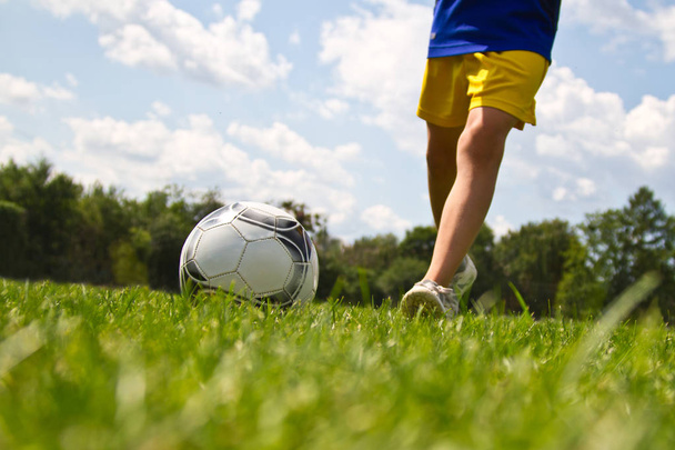 Legs of soccer player kicking the ball - Φωτογραφία, εικόνα