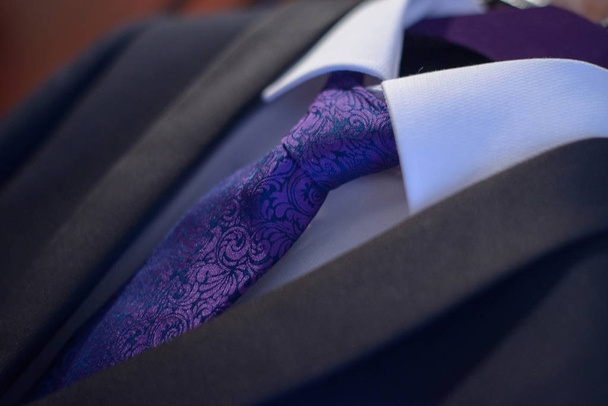 Traje elegante de primer plano con camisa blanca y corbata de seda púrpura atada en un nudo Windsor en preparación para un evento formal, entrevista de trabajo o una ceremonia de boda, o como parte del atuendo de oficina
 - Foto, imagen