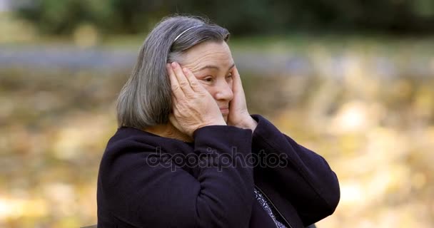 Femme âgée déprimée pensant inquiet à l'extérieur dans le parc
. - Séquence, vidéo