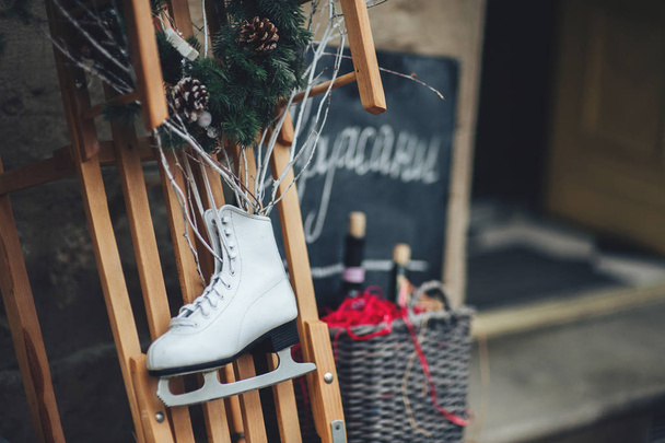Vintage ice skate for figure skating with fir tree branch hanging on rustic background. Christmas decoration. - Фото, зображення