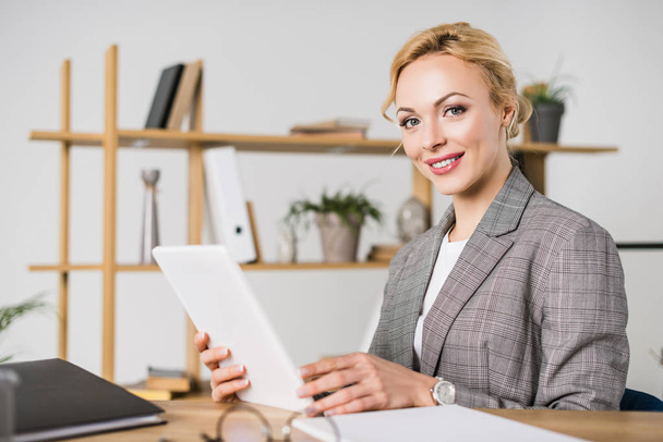 portrait of attractive businesswoman with tablet sitting at workplace - Photo, Image