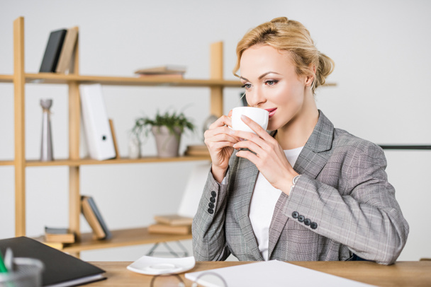 retrato de hermosa mujer de negocios con taza de café en el lugar de trabajo
 - Foto, imagen