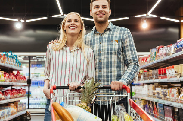Cute couple grocery shopping together - Foto, afbeelding