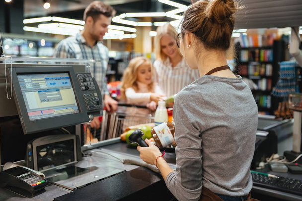 Beautiful family standing at the cash counter - 写真・画像