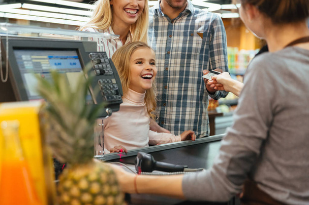 Cheerful family paying with a credit card - Fotó, kép