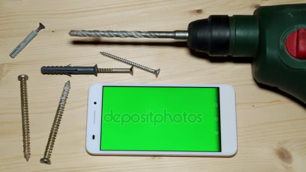 Οικοδομικά Εργαλεία και ένα smartphone με μια πράσινη οθόνη. - Πλάνα, βίντεο
