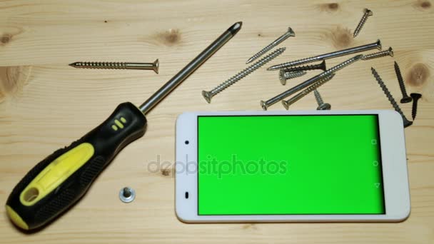 Destornillador de mano, tornillos y smartphone con pantalla verde
. - Imágenes, Vídeo