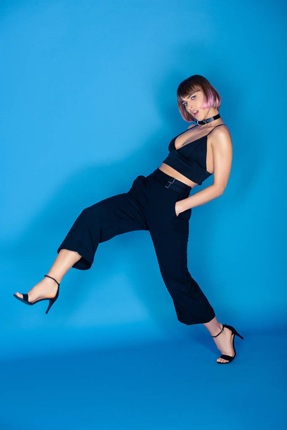 beautiful fashionable girl posing with leg up on blue - Foto, Imagem