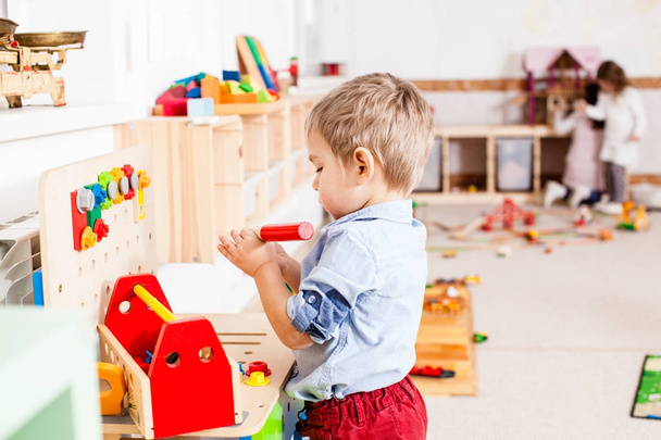 Boy plays with wooden toys - Фото, изображение