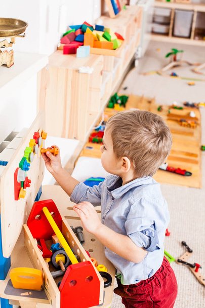 Boy plays with wooden toys - Фото, изображение