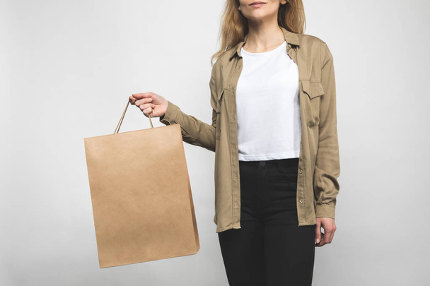 woman in stylish shirt on white with shopping bag - Фото, изображение