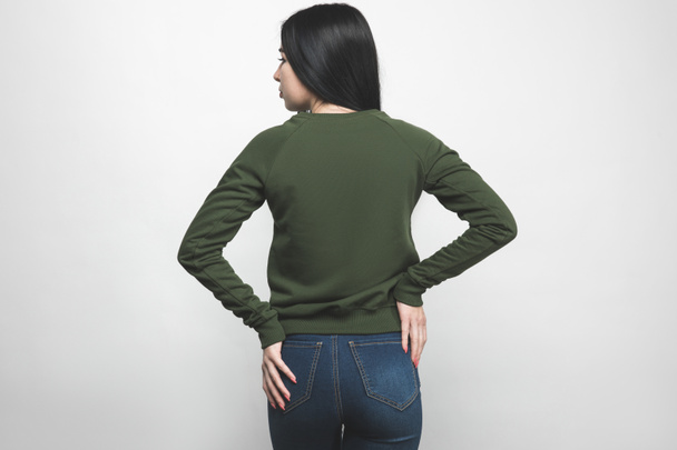back view of young woman in blank green sweatshirt on white - Фото, изображение