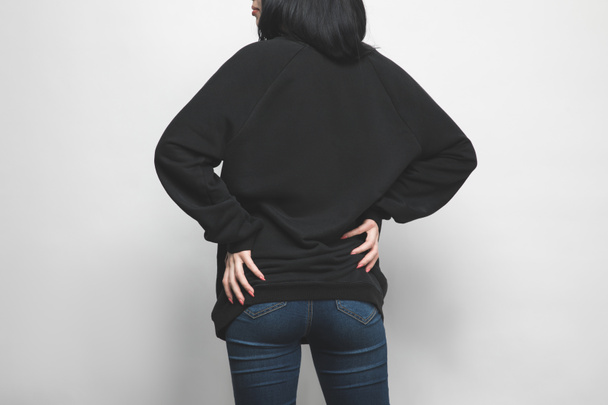 rear view of young woman in black hoodie on white - Valokuva, kuva