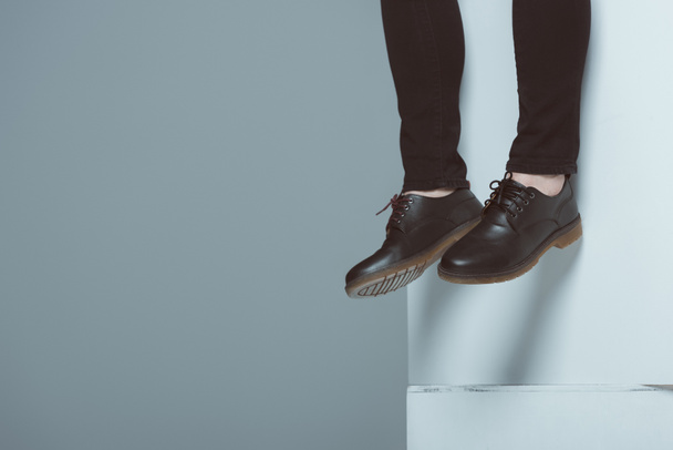 cropped view of man in trendy shoes on white cubes, isolated on grey - Fotografie, Obrázek