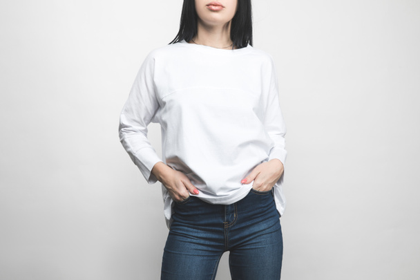 cropped shot of young woman in blank sweatshirt on white - Fotó, kép