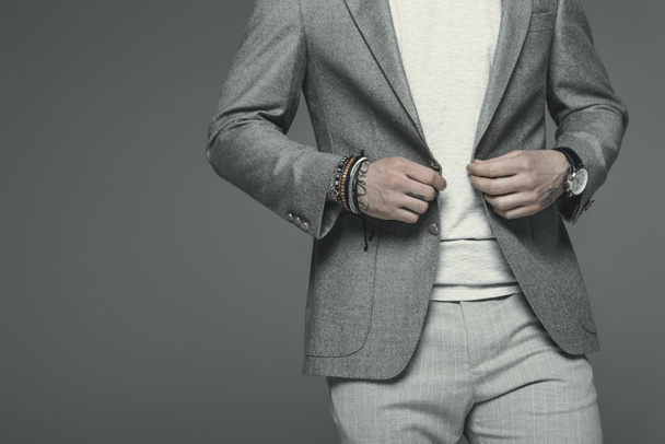 Ausgeschnittene Ansicht eines Geschäftsmannes im grauen Anzug, isoliert auf grau - Foto, Bild
