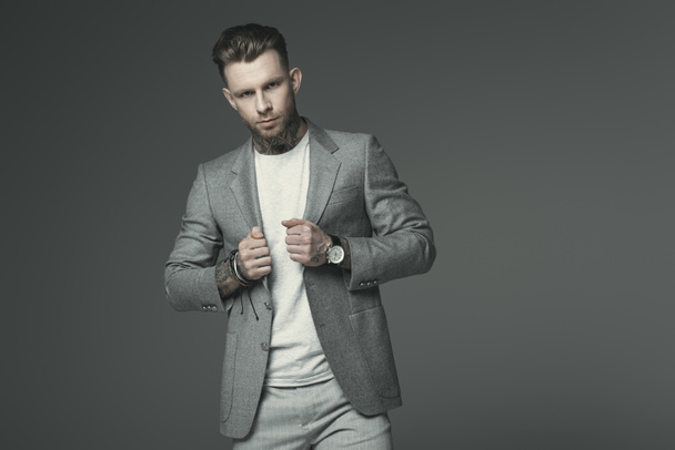 stylish businessman in grey suit, isolated on grey - Foto, afbeelding