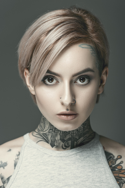 young attractive tattooed girl, isolated on grey - Fotografie, Obrázek