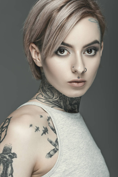 beautiful tattooed girl, isolated on grey - Foto, imagen