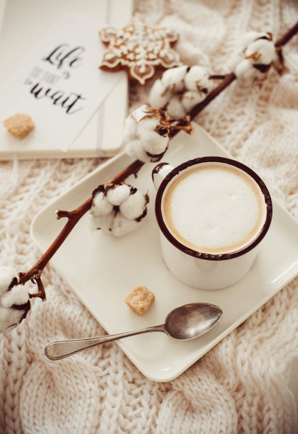 Taza de bebida caliente con rama de algodón en manta de invierno acogedor blanco
 - Foto, imagen