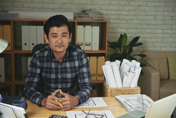 Engenheiro vietnamita sentado em sua mesa de escritório
 - Foto, Imagem