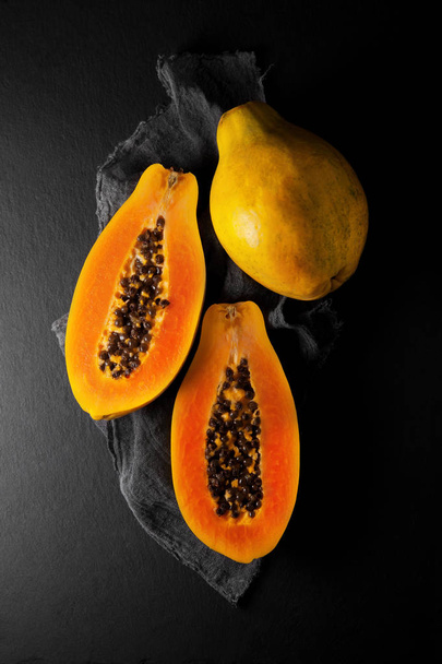 fresh ripe papaya on a napkin and slate plate kitchen table can be used as background - Foto, Imagem