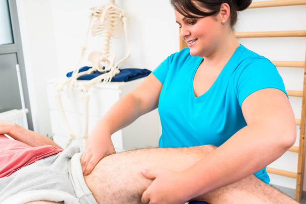 Physical therapist massages male leg - Photo, Image