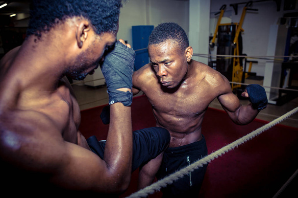 Luchador ofensivo determinado golpeando a su oponente mientras practica
 - Foto, imagen