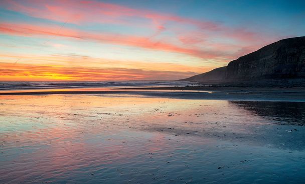 Pôr do sol sobre a praia em Dunraven Bay
  - Foto, Imagem