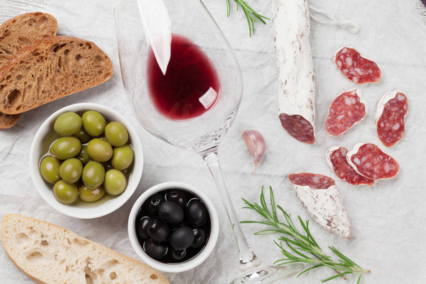 Salám, klobása, olivy, toasty a sklenka na červené víno. Maso předkrmů. Pohled shora - Fotografie, Obrázek